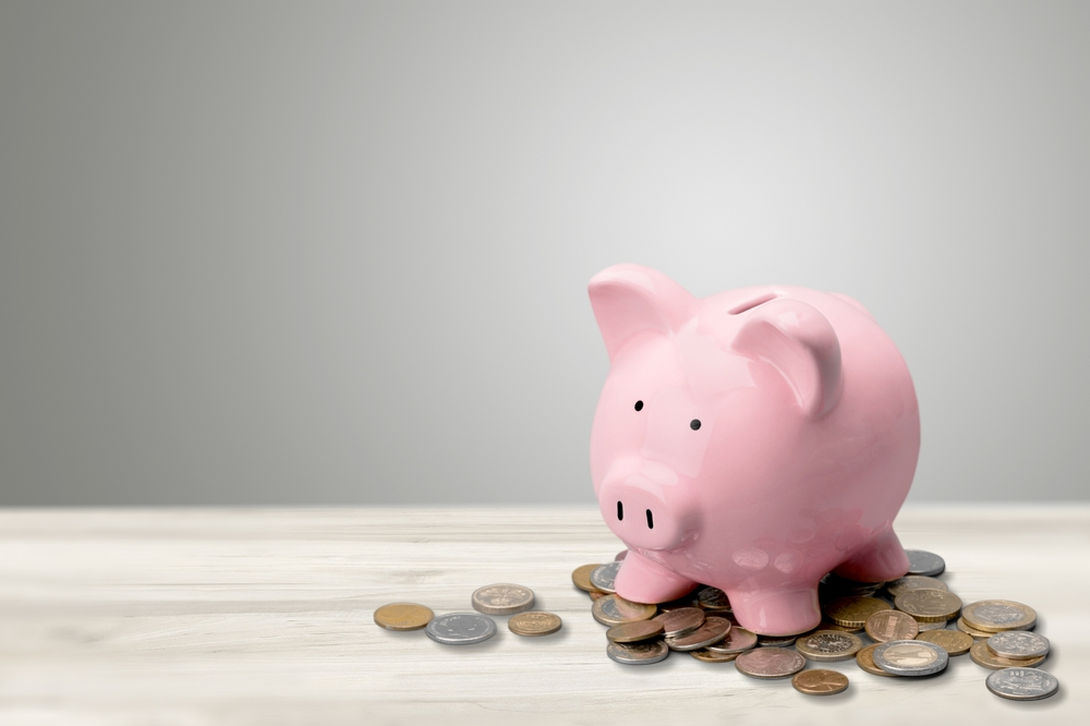 pink piggy bank on pile of coins