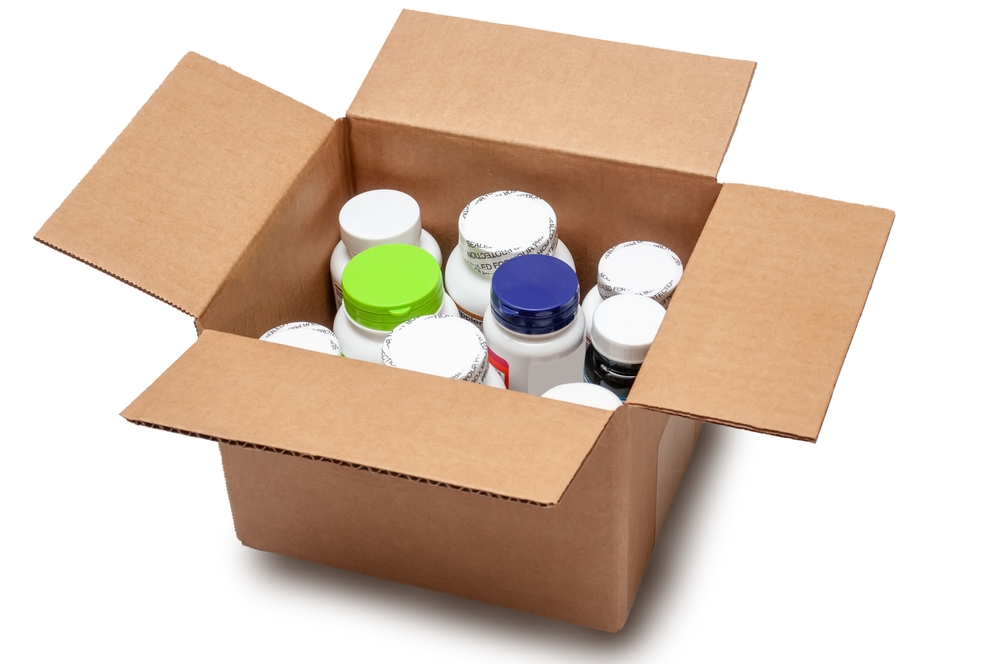 open cardboard box filled with assorted supplement bottles