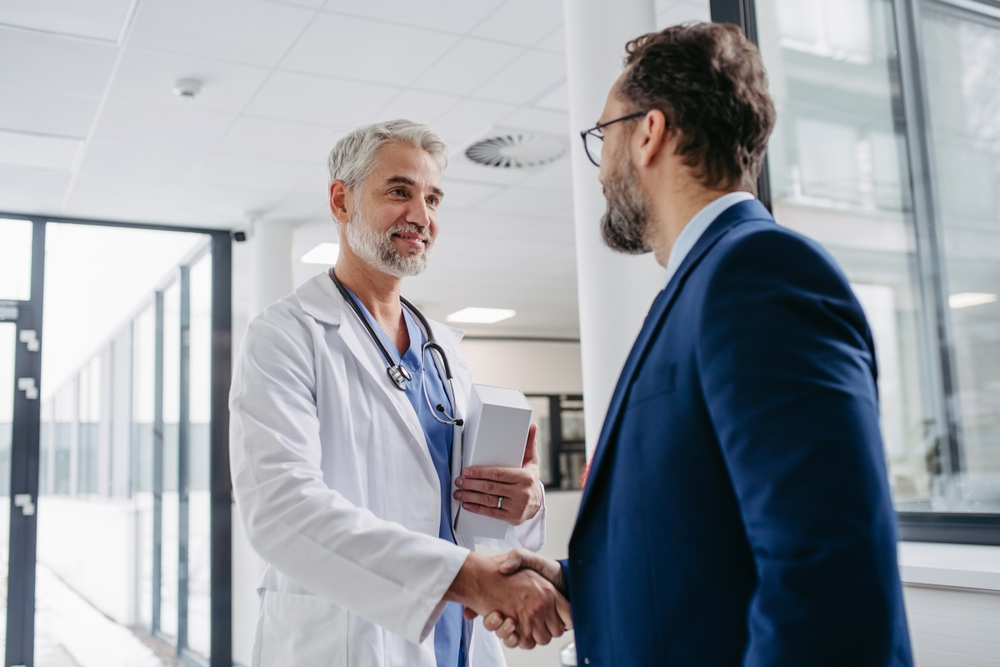 man in suit shaking hands with doctor