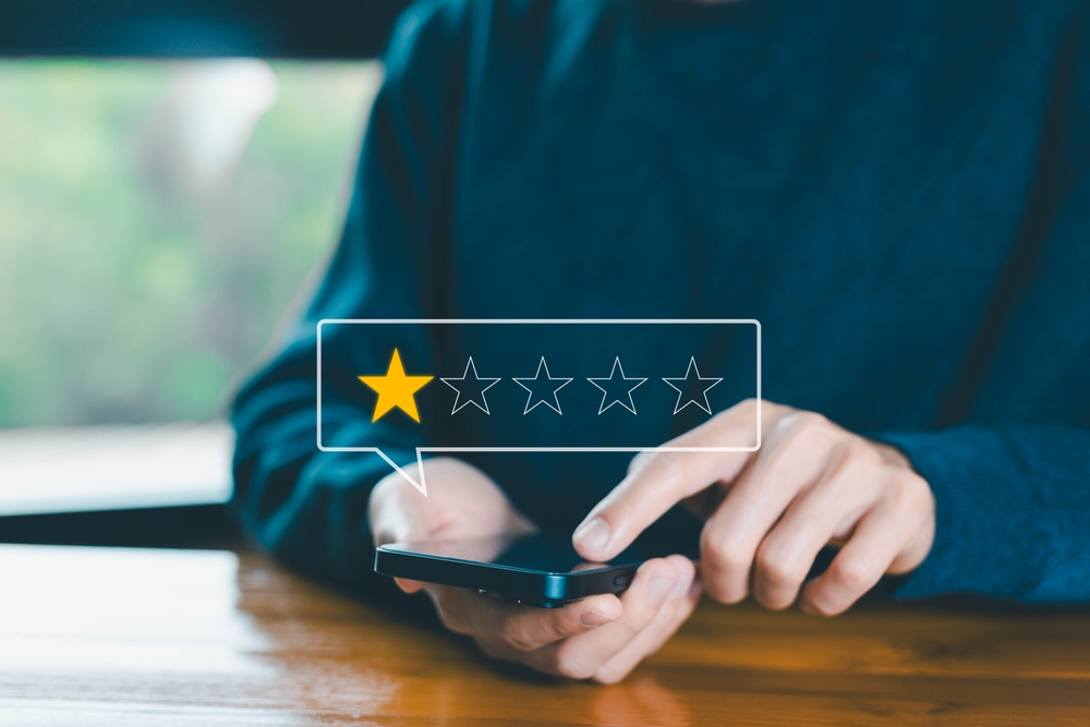 person rating business with 1 star on smartphone